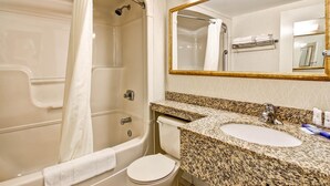 A bathroom with a bathtub, toilet, sink, and a large mirror. - Quality Inn (Kitchener)