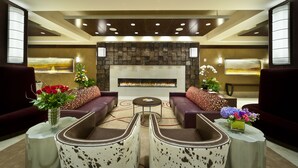 A modern lounge area with sofas, a coffee table, and a fireplace. - Northern Hotel (Billings)