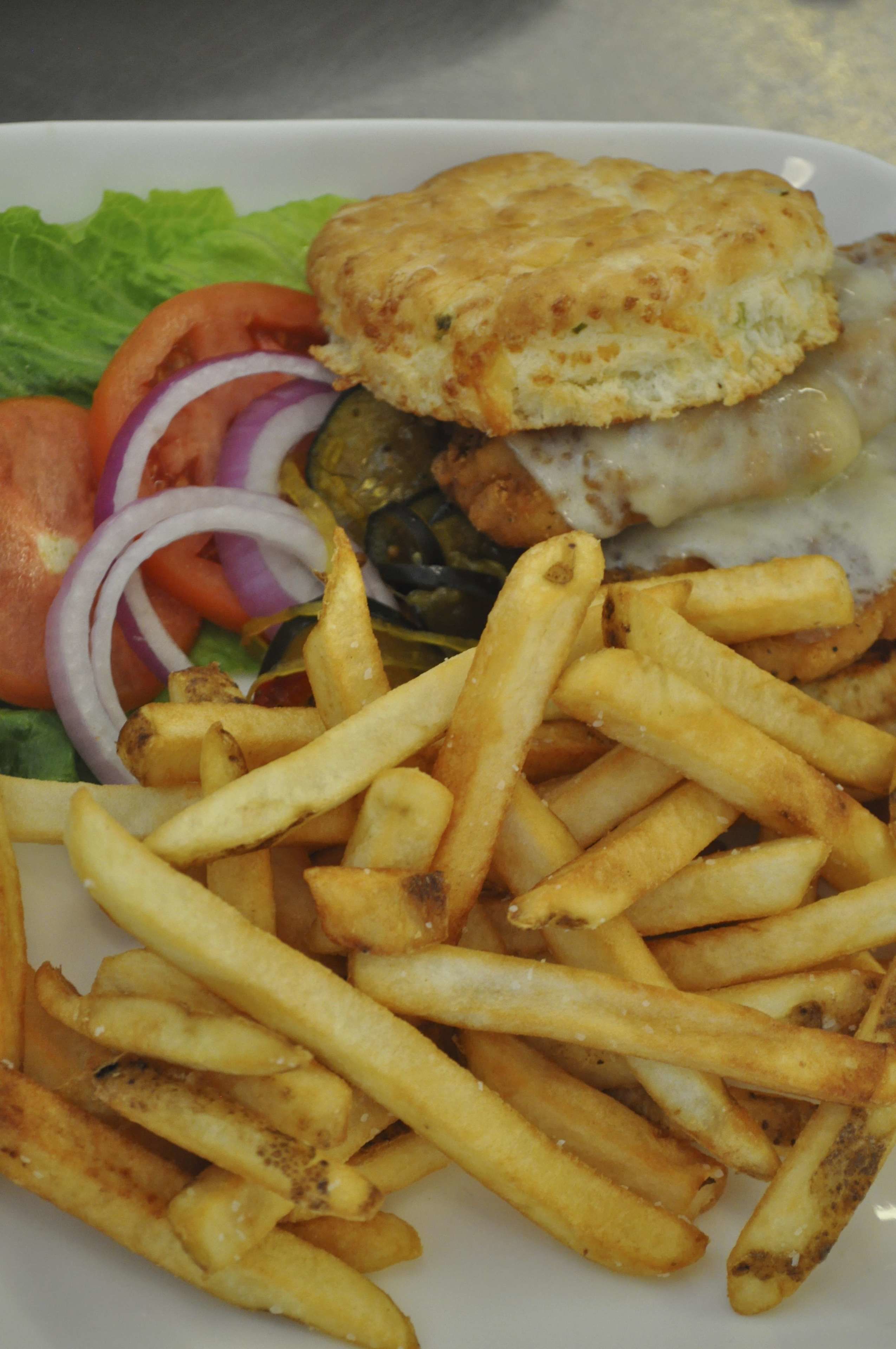 Une assiette de frites, un biscuit et un sandwich aux légumes.