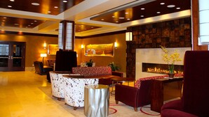 A lobby with a reception desk, seating area, and a fireplace. - Northern Hotel (Billings)