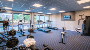 A gym with treadmills, elliptical machines, and weightlifting equipment.