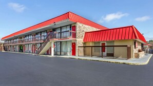 A motel with a red roof, multiple balconies, and a central staircase. - Econo Lodge Roanoke Civic Center (Roanoke)