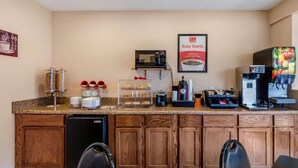 A hotel reception area with a coffee station, microwave, and a juice dispenser. - Econo Lodge Roanoke Civic Center (Roanoke)
