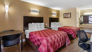 A hotel room with two beds, a desk, and a chair.