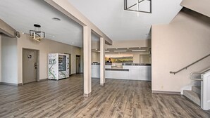 A spacious interior with a kitchen area, wooden flooring, and a modern light fixture. - Days Inn by Wyndham Novato/San Francisco (Novato)