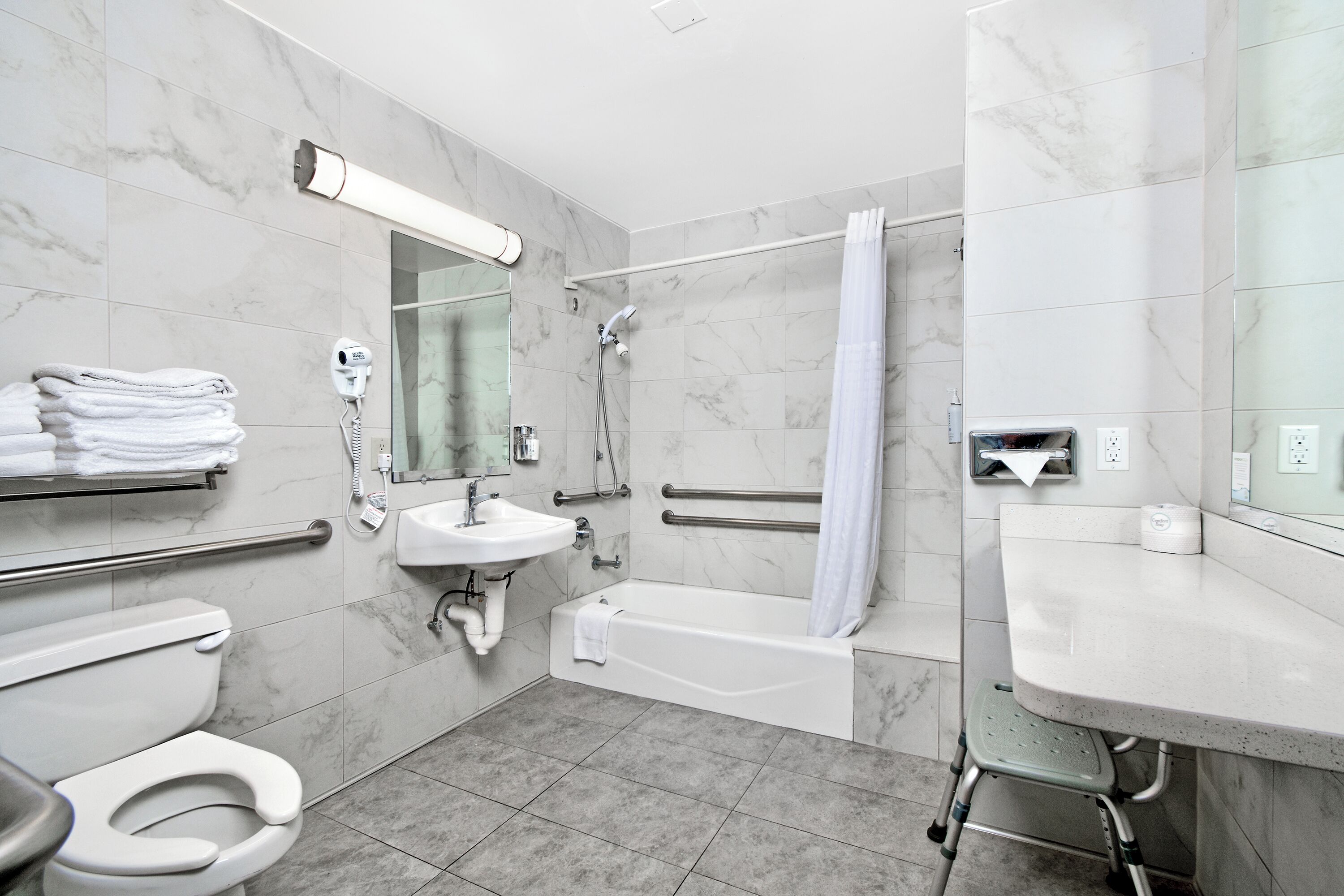 A modern bathroom with a toilet, sink, shower, and bathtub.