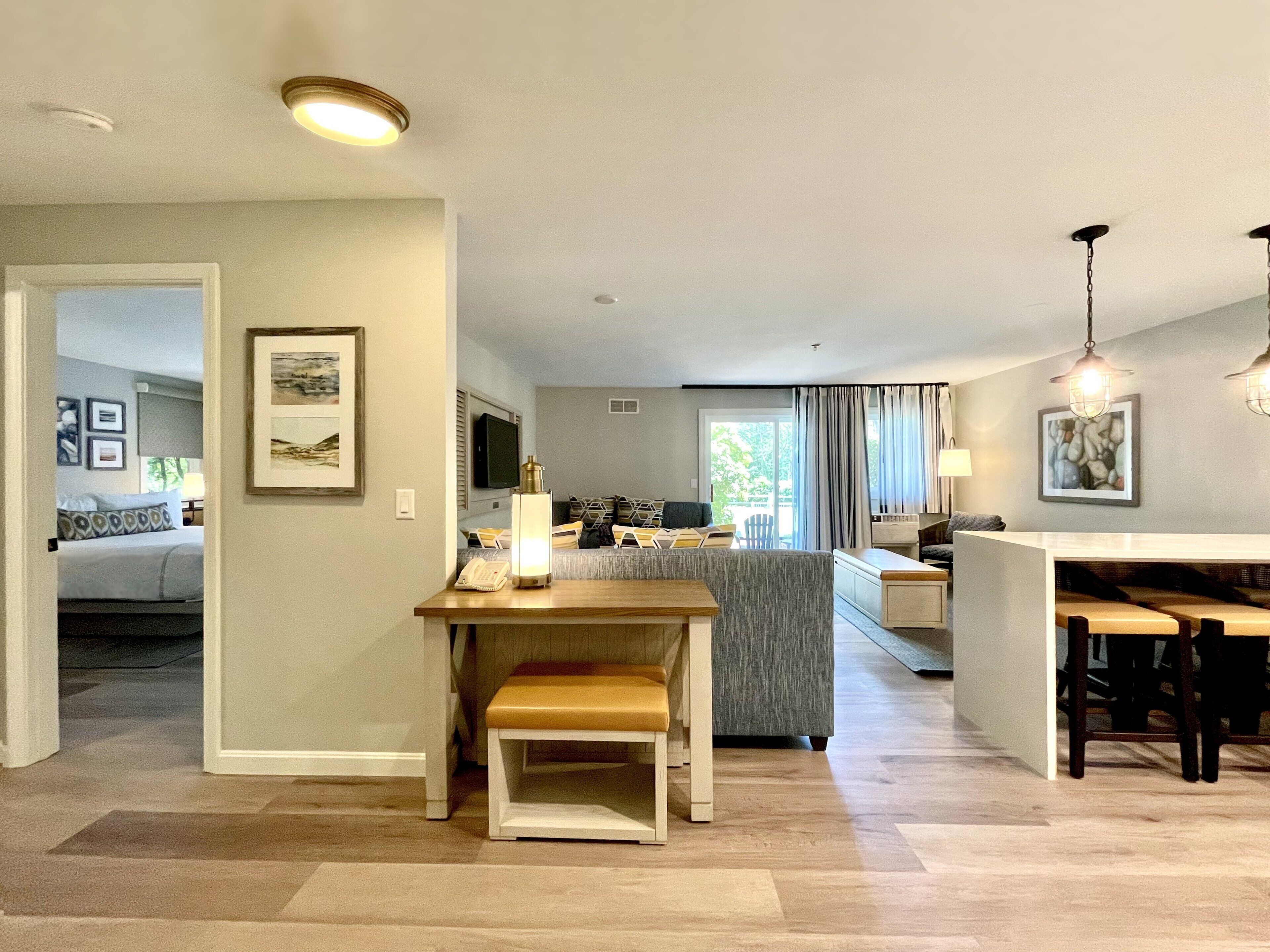 Una sala de estar moderna con sofá, una mesa de centro y una zona de comedor con banco y mesa.