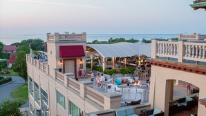 A rooftop bar with outdoor seating and a view of the water. - The Mansion at Ocean Edge (Brewster)