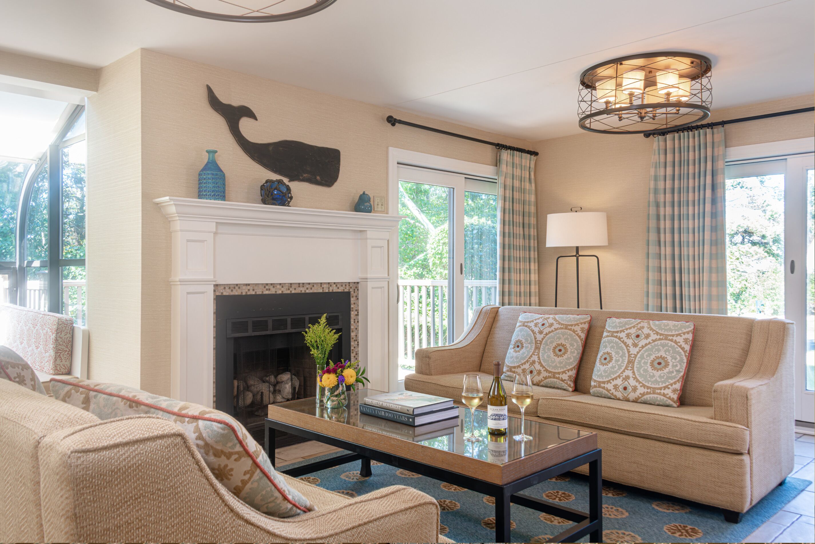 A living room with a fireplace, a sofa, a coffee table, and a chandelier.