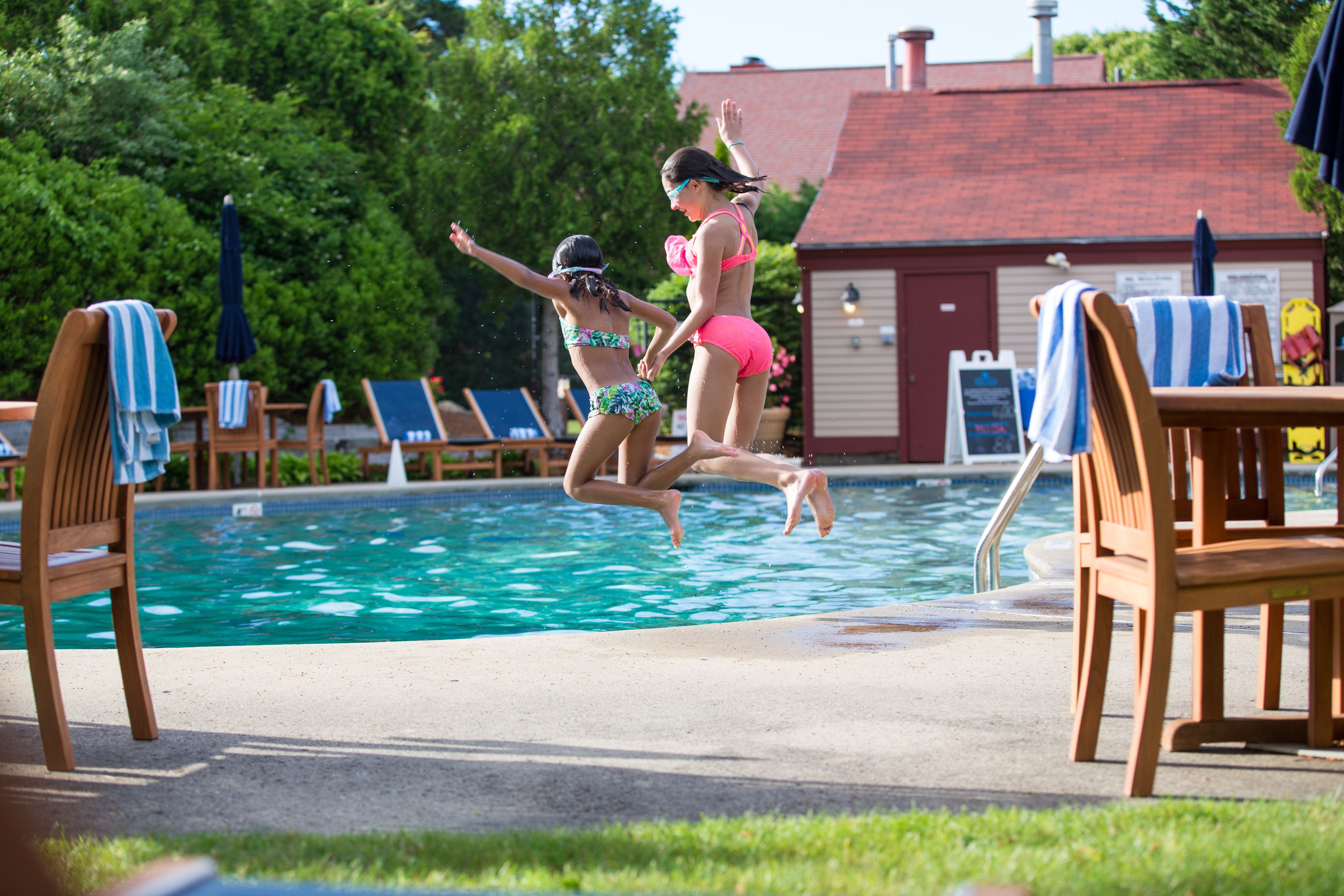 A swimming pool with lounge chairs and umbrellas.