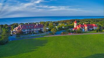 A large estate with multiple buildings, a well-maintained lawn, and a view of the sea.