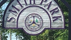 Un panneau d’accueil pour le parc Smith, orné d’un emblème circulaire au centre.