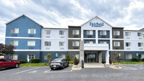 Een meerlaags Fairfield by Marriott hotel met een parkeerplaats ervoor.