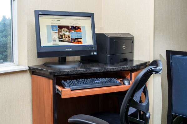 Una computadora de escritorio con monitor, teclado y ratón sobre un escritorio de madera.