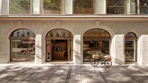 A storefront with a wine shop named 'VINOTHEK' and a bicycle parked in front. - Hotel Excelsior München (Munich)
