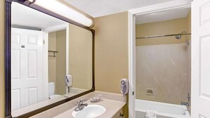 Un baño con lavamanos, espejo y ducha.