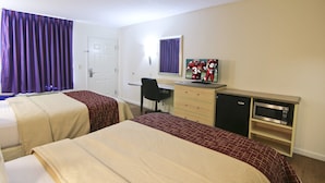 Une chambre d’hôtel avec deux lits, un bureau, une chaise, une télévision et un mini-bar.