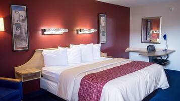 Ein Hotelzimmer mit Bett, Nachttischen, einem Schreibtisch und einem Stuhl.