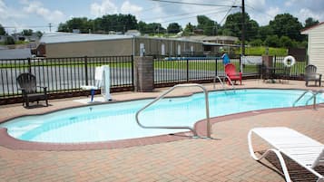 Una piscina al aire libre de temporada, sombrillas