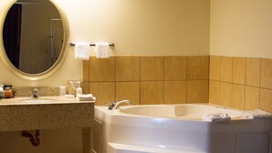A bathroom with a large bathtub, a sink, and a mirror. - Red Roof Inn Somerset, KY (Somerset)