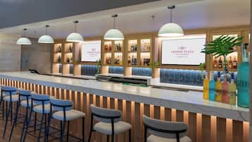 A hotel reception area with a bar, seating, and a display of liquor bottles.