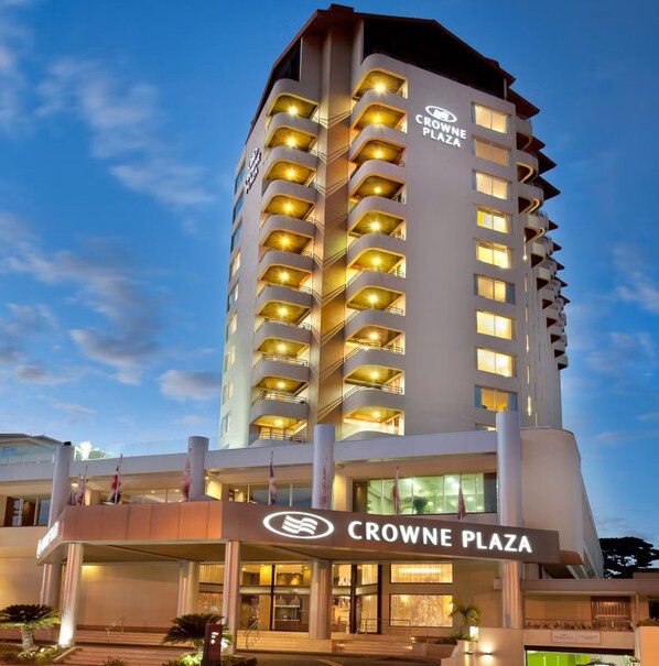 A high-rise hotel with multiple balconies, a prominent entrance, and a clear sky in the background. - Crowne Plaza Santo Domingo by IHG (Santo Domingo)