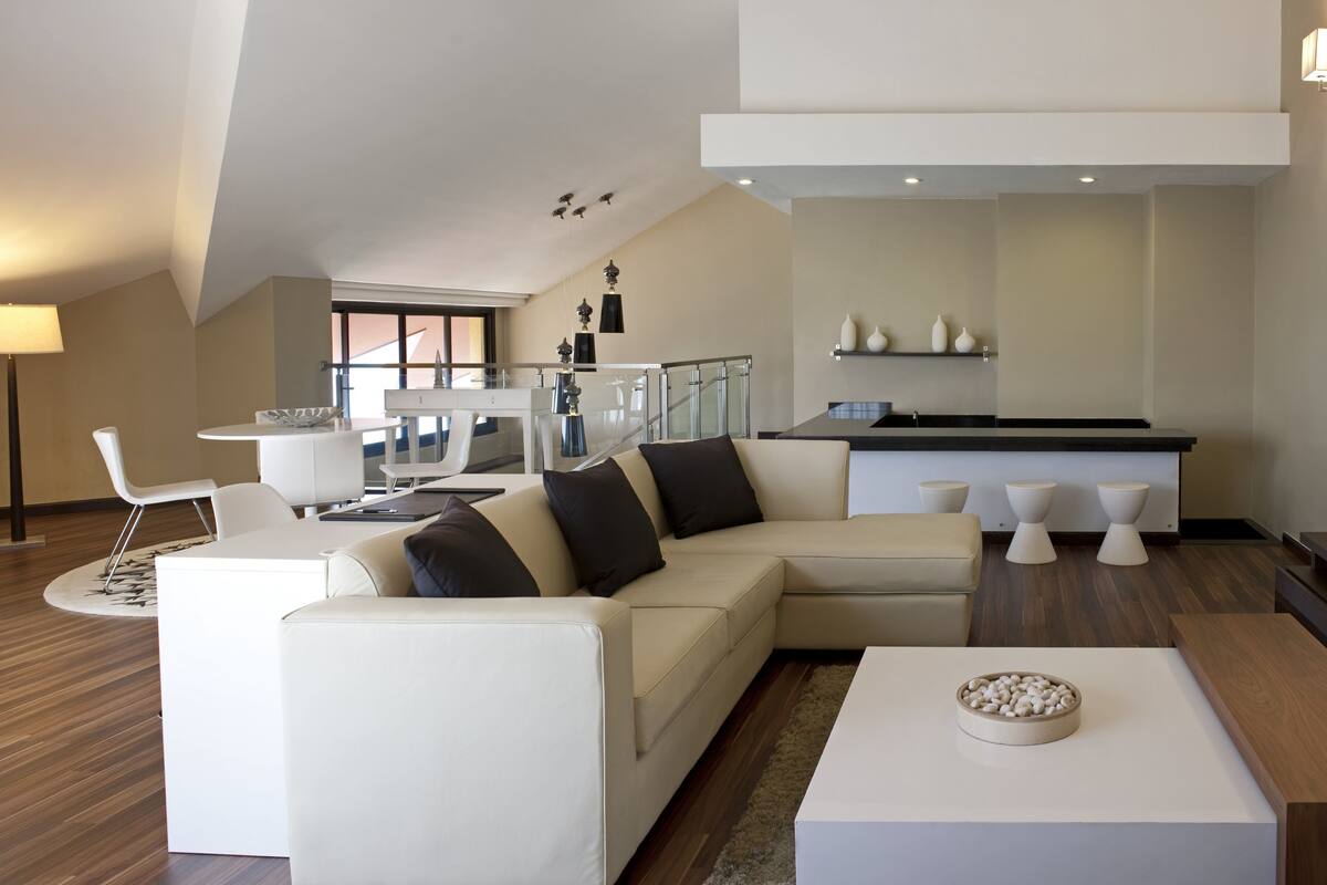 Un salon moderne comprenant un canapé, une table basse et un coin repas avec une table et des chaises.