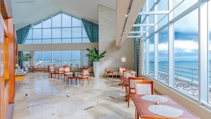 A spacious dining area with high ceilings and large windows overlooking the sea. - Crowne Plaza Santo Domingo by IHG (Santo Domingo)