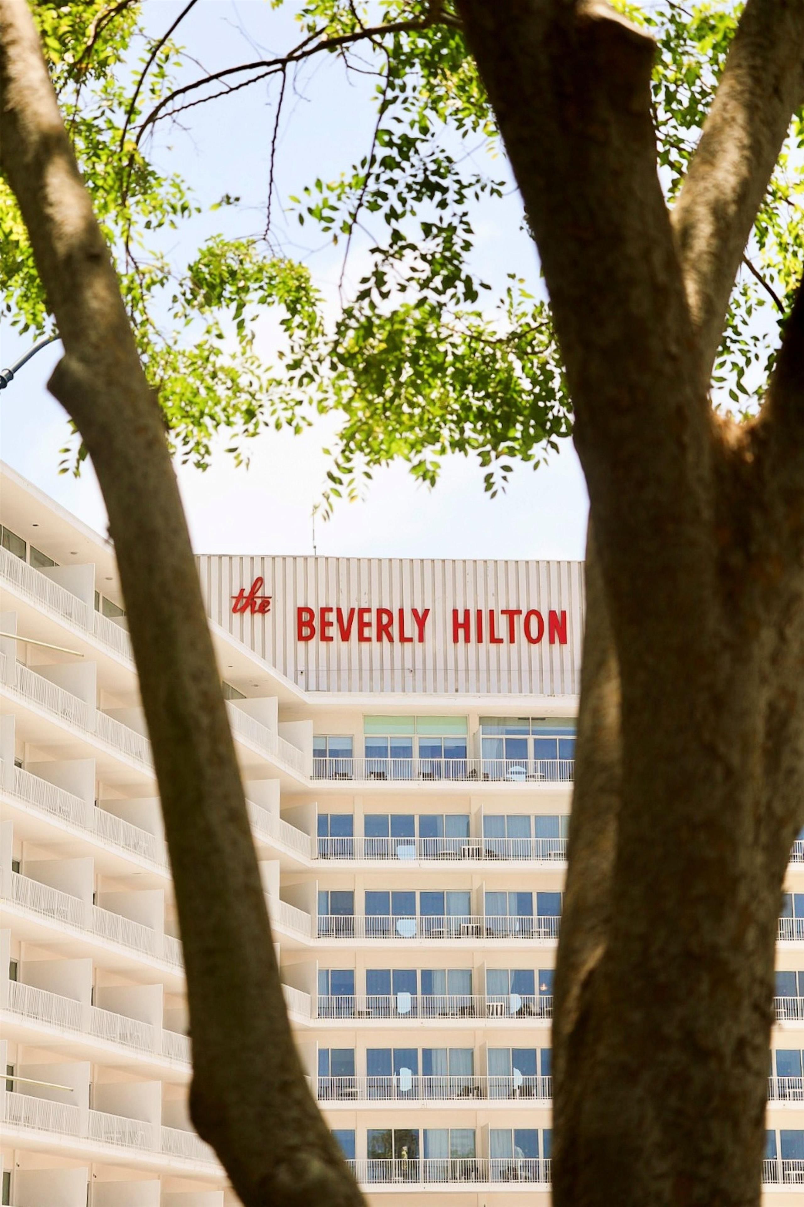 A multi-story hotel building with a prominent sign reading 'BEVERLY HILTON.'