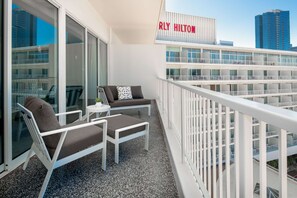A balcony with two lounge chairs, a small table, and a potted plant. A sign reading "RLY HILTON" is visible above. - The Beverly Hilton (Beverly Hills)