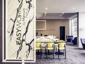 A modern conference room with a marble wall, yellow chairs, a long table, and a 'WORK' sign on the wall.