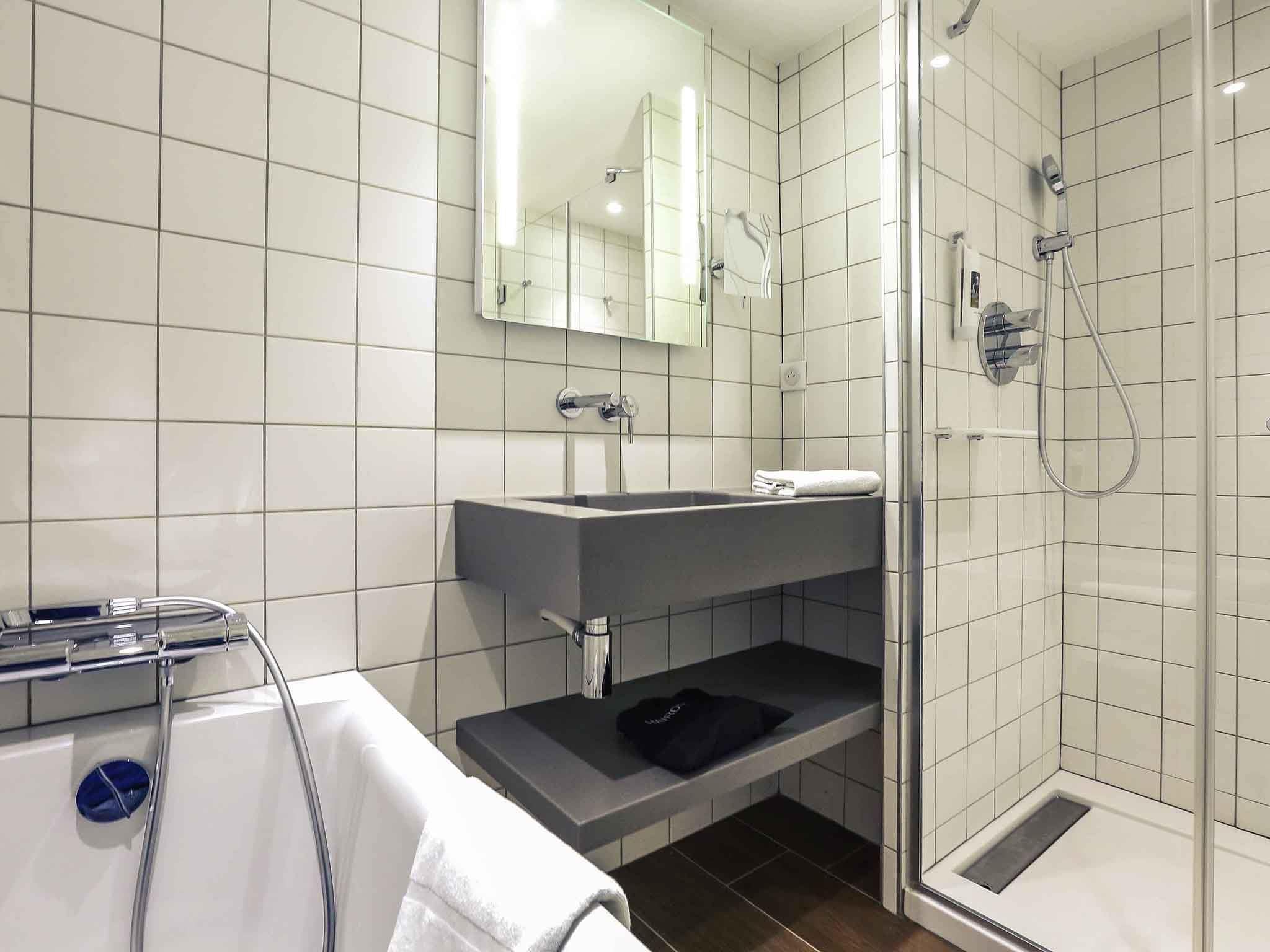 Ein modernes Badezimmer mit einer Duschkabine, einem Waschtisch und einem Handtuchhalter.
