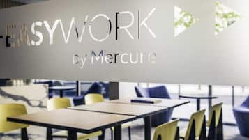 Een modern interieur met een bord waarop 'EASYWORK by Mercure' staat.