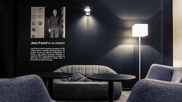 A modern interior with a sofa, two round tables, and a floor lamp.