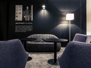A modern interior with a sofa, two round tables, and a floor lamp.