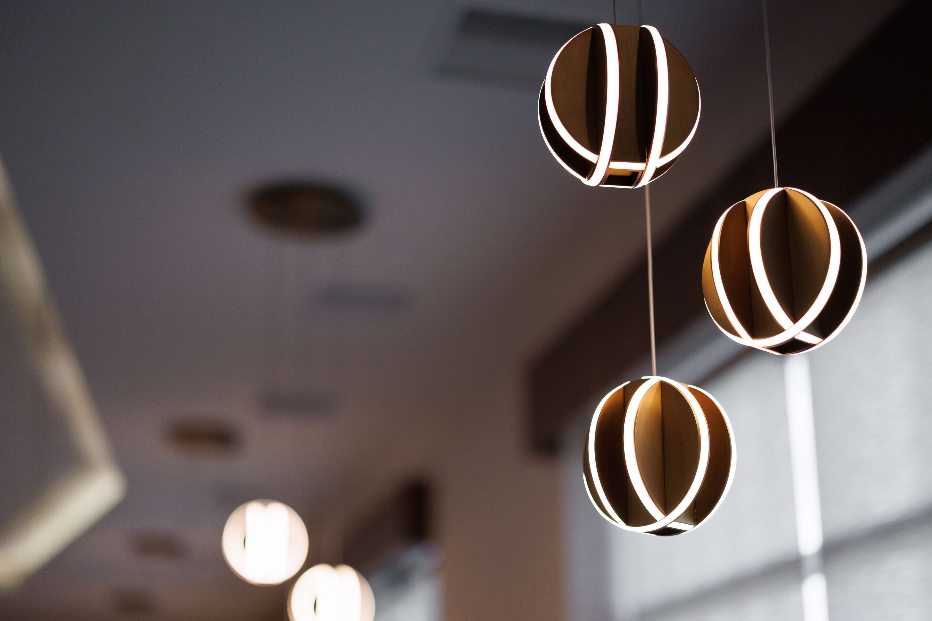 A modern interior with spherical hanging lights and recessed ceiling lights.