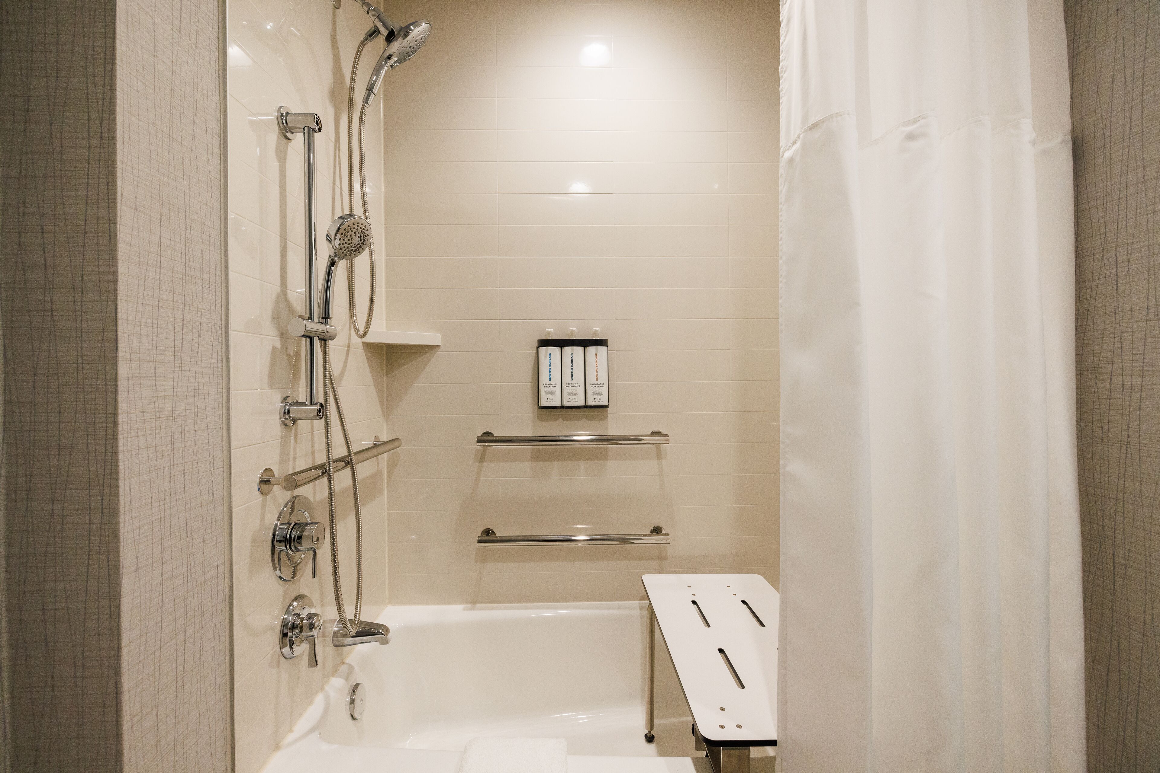 A modern bathroom with a bathtub, shower, and towel rack.