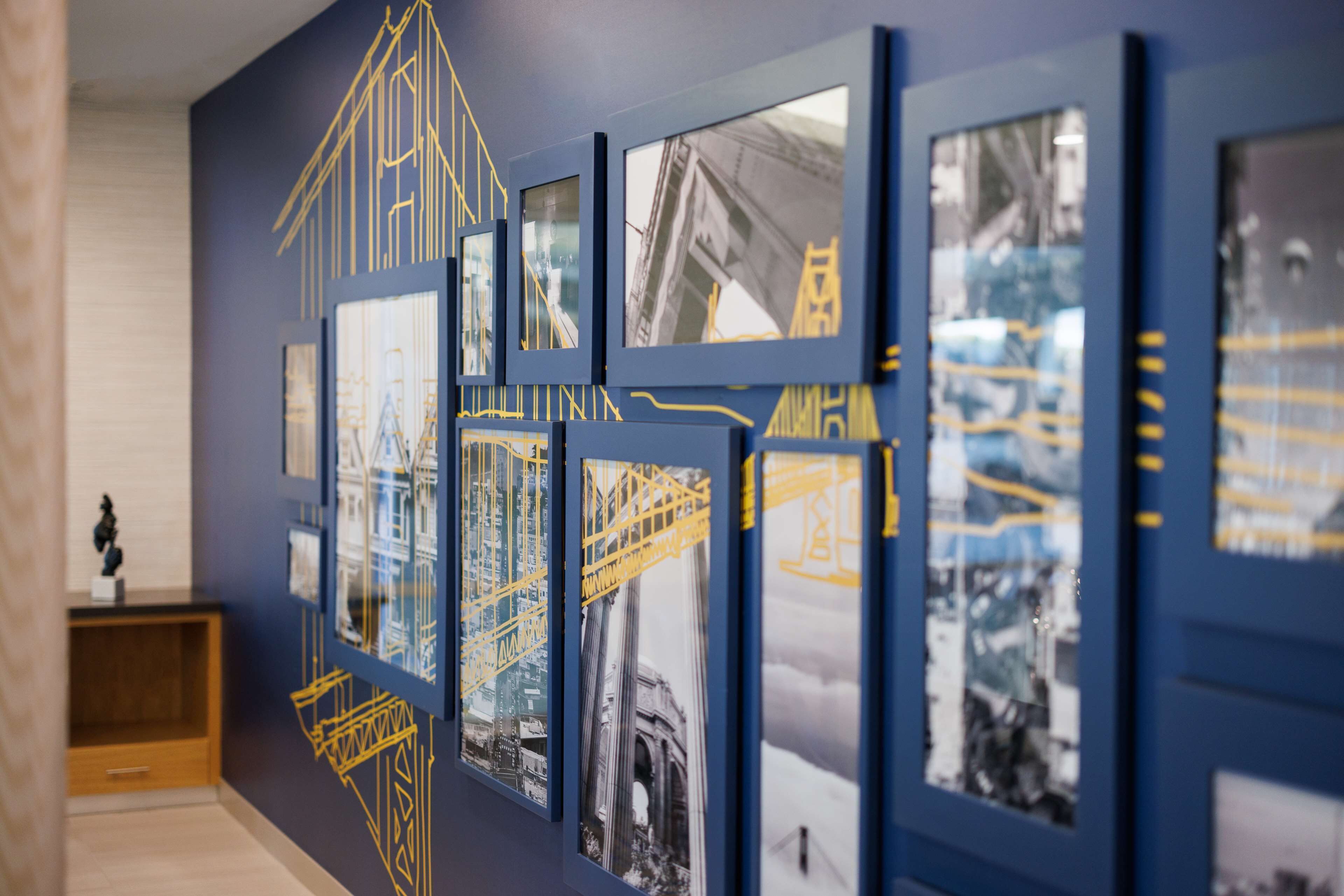Una pared galería con fotografías enmarcadas de estructuras arquitectónicas y sitios de construcción.