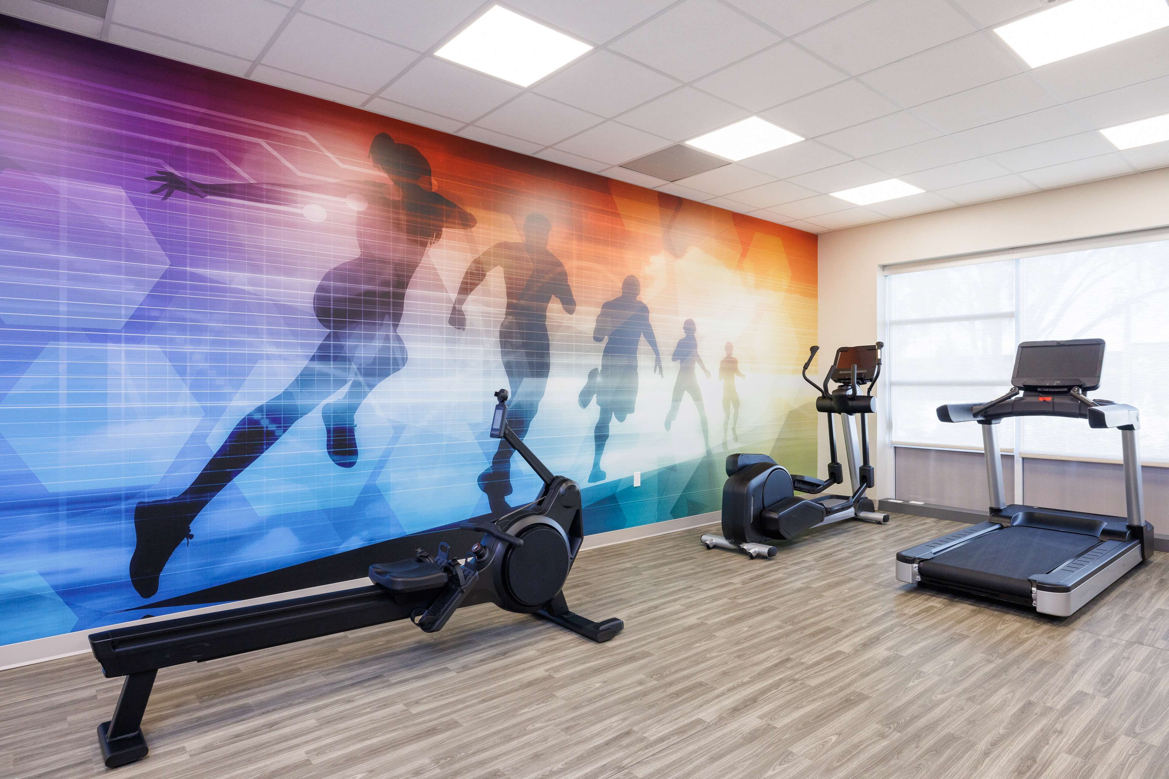 A gym with exercise equipment including treadmills, an elliptical, and a stationary bike.