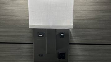 A wall-mounted light fixture with a rectangular cover and two electrical outlets below it.