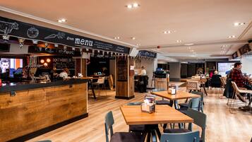 A restaurant with a wooden counter and seating area.