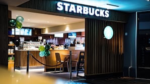 A Starbucks store with a wooden facade, a bar area, and seating. - Village Hotel Manchester Cheadle (Cheadle)