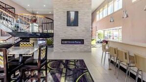 Eine geräumige Lobby mit Treppe, Kamin und Sitzbereichen.