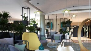 A modern lobby with seating areas, hanging pendant lights, and potted plants. - The Jangle Hotel - Paris - Charles de Gaulle - Airport (Le Mesnil-Amelot)