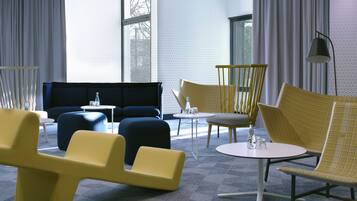 A modern lounge area with a sofa, chairs, and a small table.