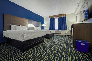 A hotel room with two beds, a desk, a trash bin, and a large window with curtains. - Baymont by Wyndham Greensburg (Greensburg)