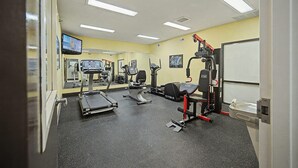 A gym with treadmills, a weight machine, and a mirror wall. - Baymont by Wyndham Greensburg (Greensburg)