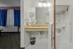 A hotel bathroom with a sink, mirror, towel rack, and a trash bin. - Baymont by Wyndham Greensburg (Greensburg)