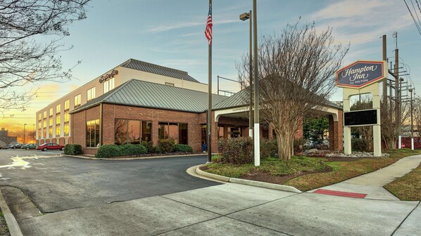 Een Hampton Inn by Hilton, met een gebouw van baksteen, een overdekte entree en een Amerikaanse vlag.