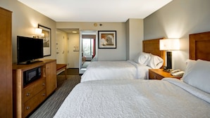 A hotel room with two beds, a TV, a microwave, and a bedside table with a lamp. - Hampton Inn Norfolk-Naval Base (Norfolk)